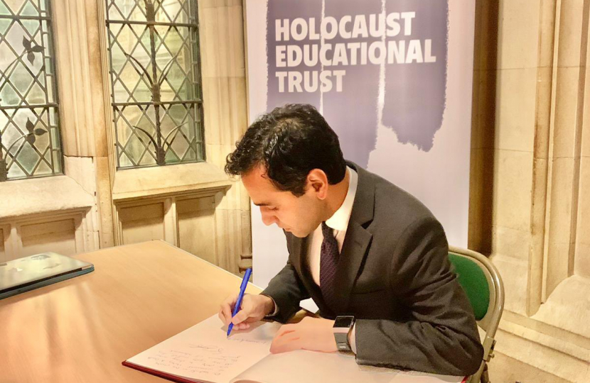 Rehman signing the Holocaust memorial book 2023